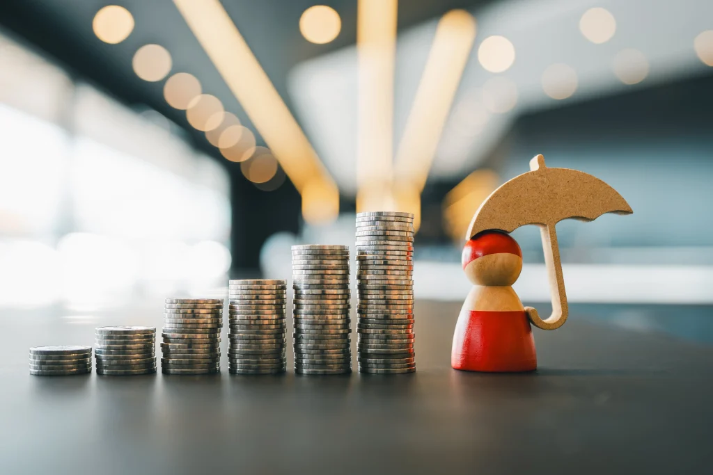 Tarification assurance représentée par piles de pièces et figurine protégée